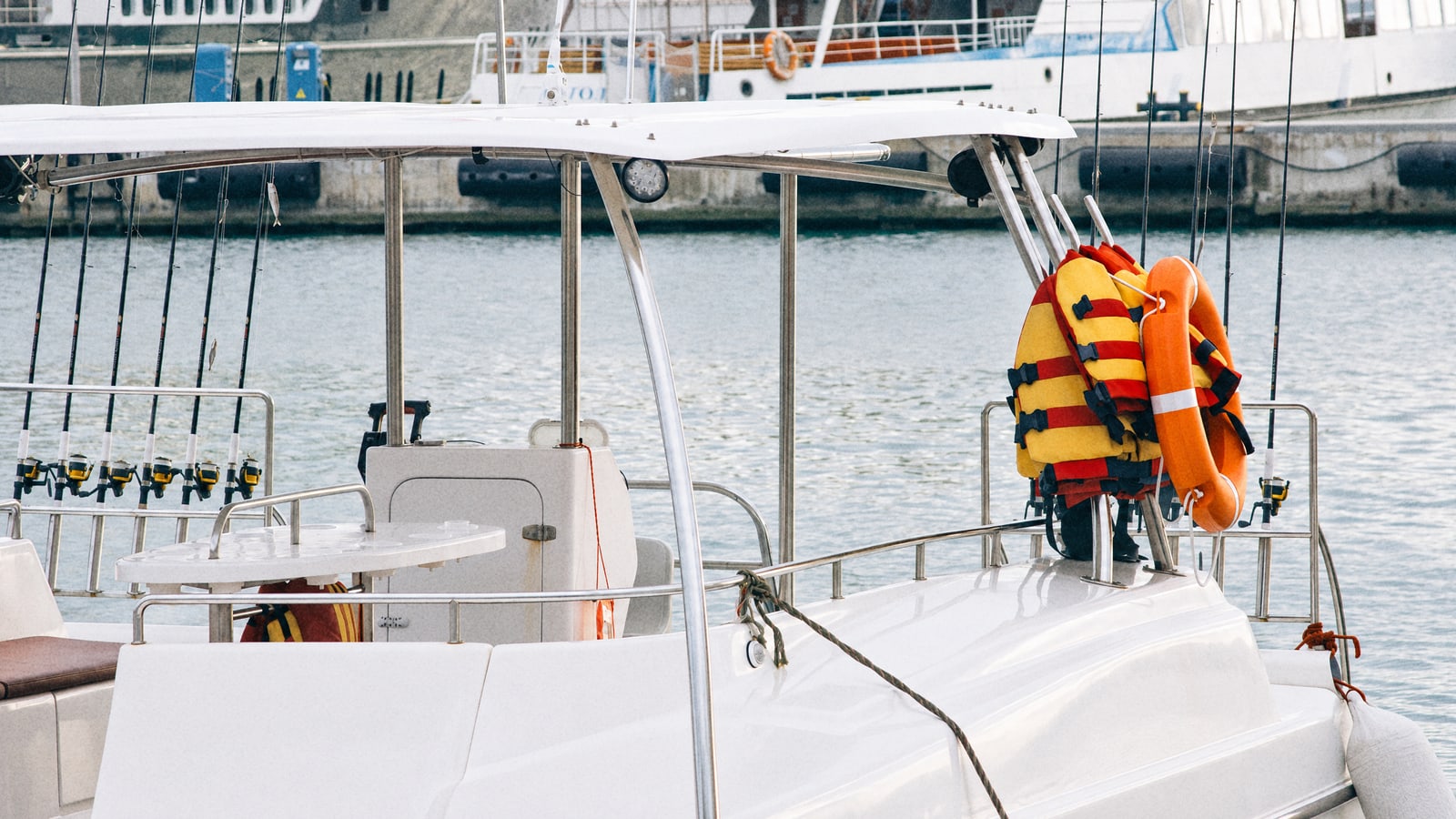 Rods, life vests and a lifebuoy on the deck of a fishing boat in the marina