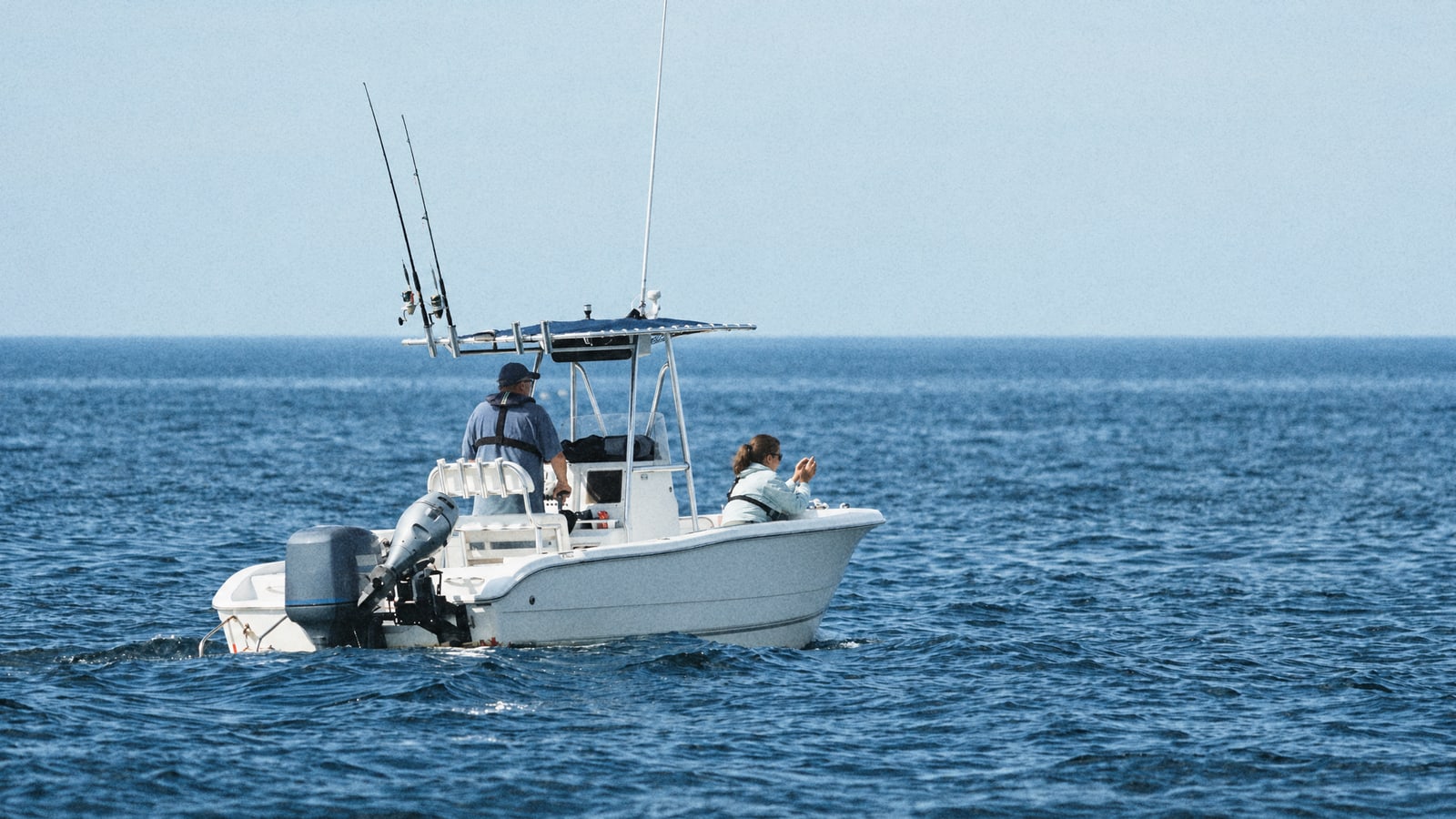A small sportfishing boat trolling offshore on a calm autumn sea, the kind of trip that targets lampuki off Malta